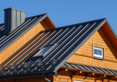 Architectural Sheet Metal and Metal Roofing - Story Roofing Close-up of a metal roof on a wooden house, showcasing architectural sheet metal work by Story Roofing.