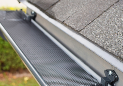 Effective Gutter Covers Installation by Story Roofing Close-up of a gutter system with a newly installed gutter cover to prevent debris buildup.