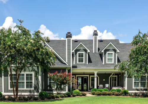 Professional Residential Roof Replacement by Story Roofing Beautiful residential home with a newly replaced gray shingle roof, surrounded by lush greenery and a well-manicured lawn.