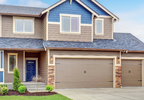 Quality Residential Roofing Installation by Story Roofing Elegant two-story residential home with a newly installed blue shingle roof and dual garage doors.