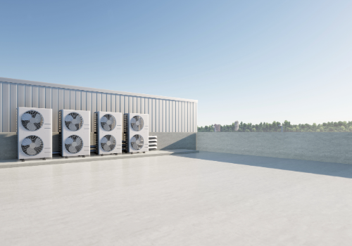 Professional Commercial Roof Replacement by Story Roofing Commercial building rooftop with multiple air conditioning units, showcasing a newly replaced flat roof under clear skies.